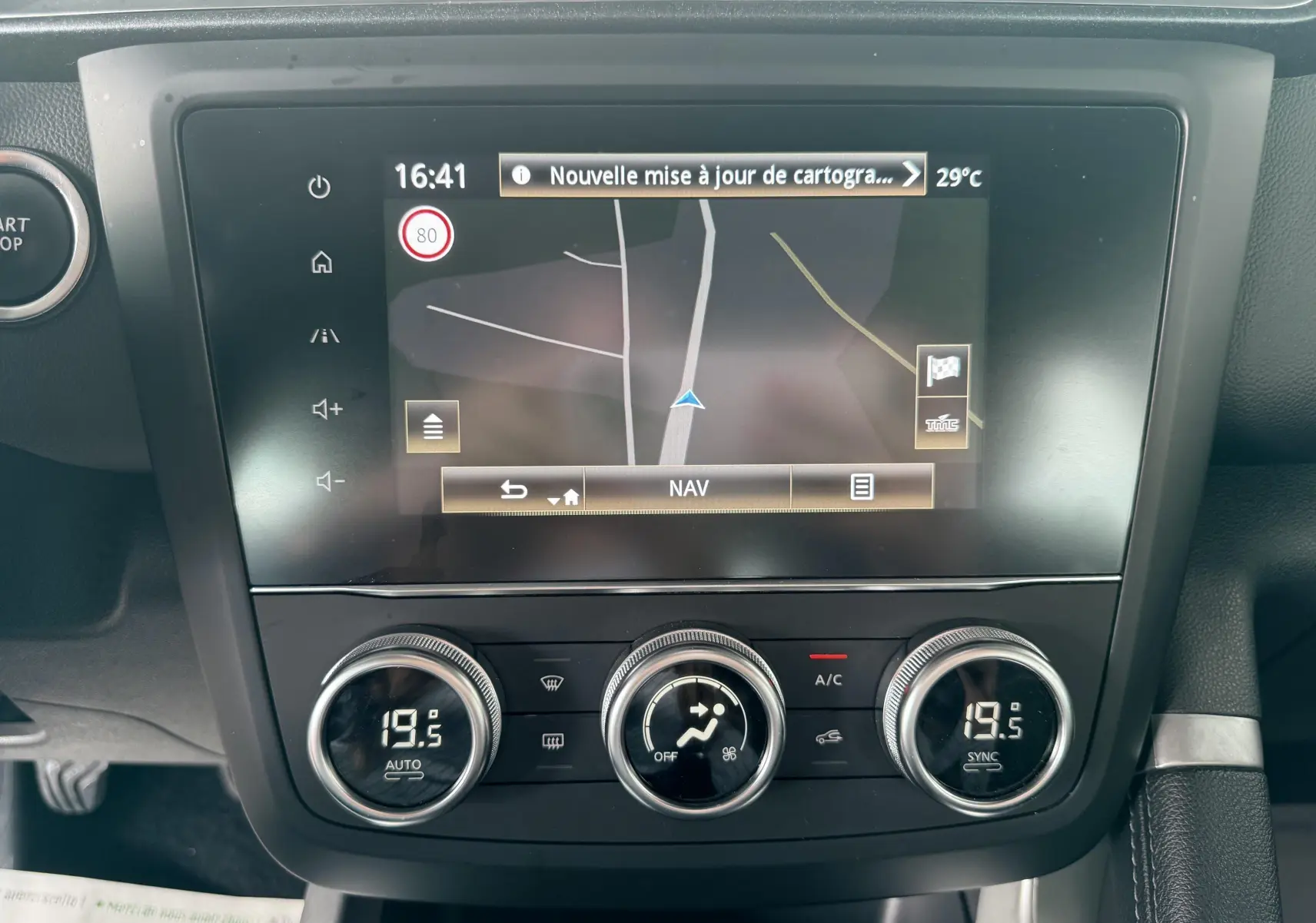 Écran tactile du système de navigation et commandes de climatisation du Renault Kadjar gris, vue frontale intérieure.