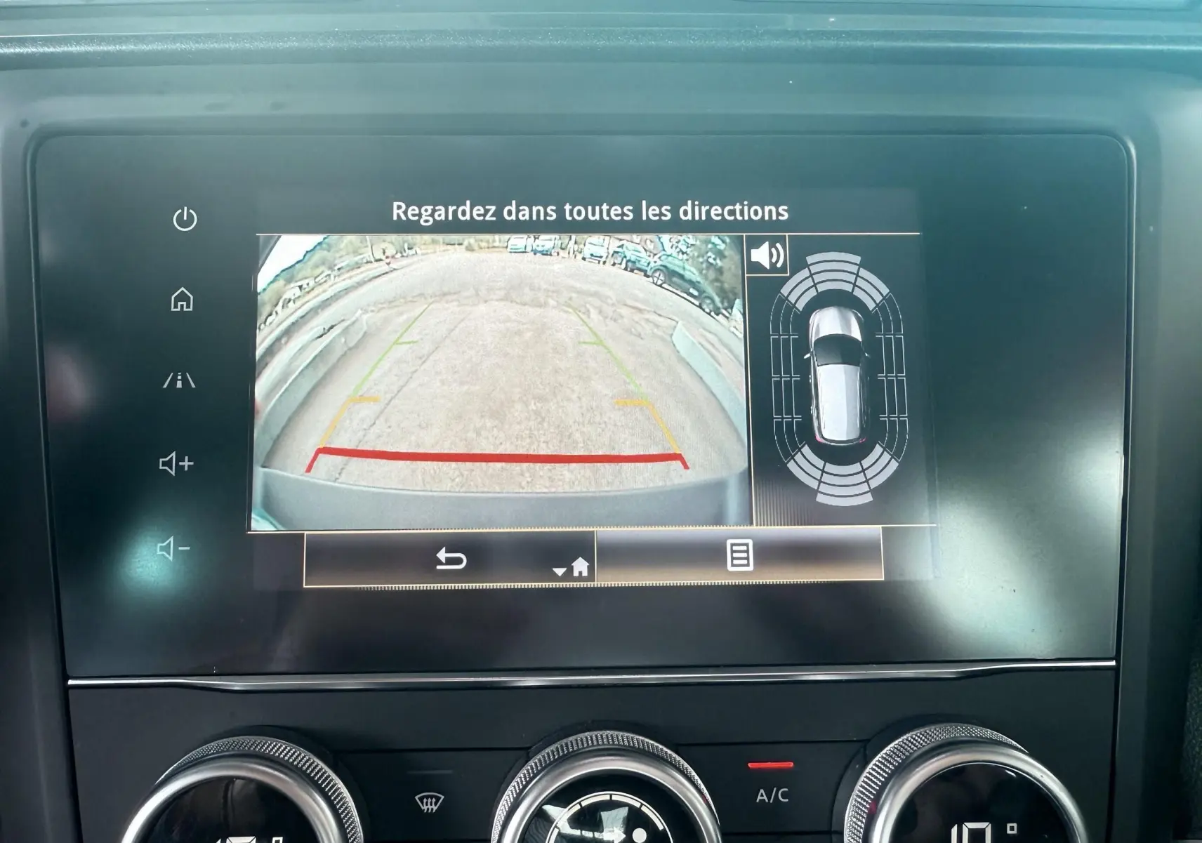 Écran de caméra de recul et capteurs de stationnement dans un Renault Kadjar gris, vue intérieure du tableau de bord.