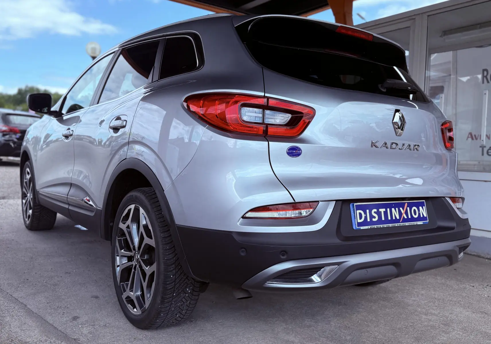 Vue 3/4 arrière gauche d'un Renault Kadjar gris avec jantes alliage et feux arrière LED distinctifs.