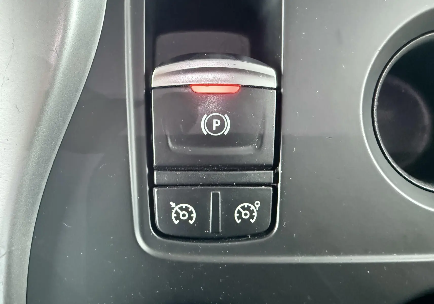 Gros plan sur les commandes du frein à main électronique et régulateur de vitesse du Renault Kadjar gris.