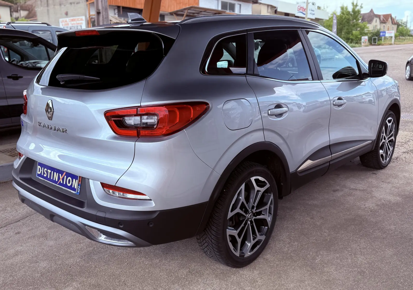 Vue 3/4 arrière droite d'un Renault Kadjar gris avec toit noir et jantes alliage au design moderne.