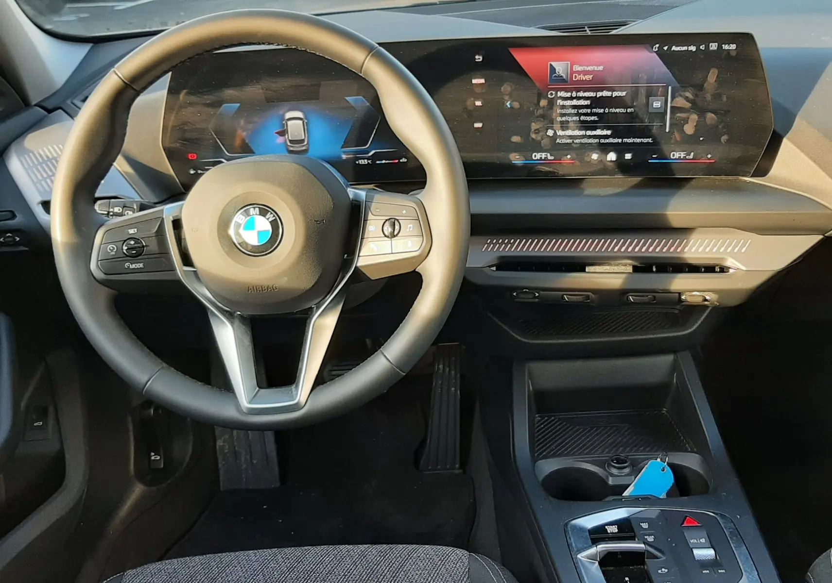 Intérieur BMW Série 1 2025 vue du conducteur, tableau de bord moderne avec écran digital et volant cuir noir.