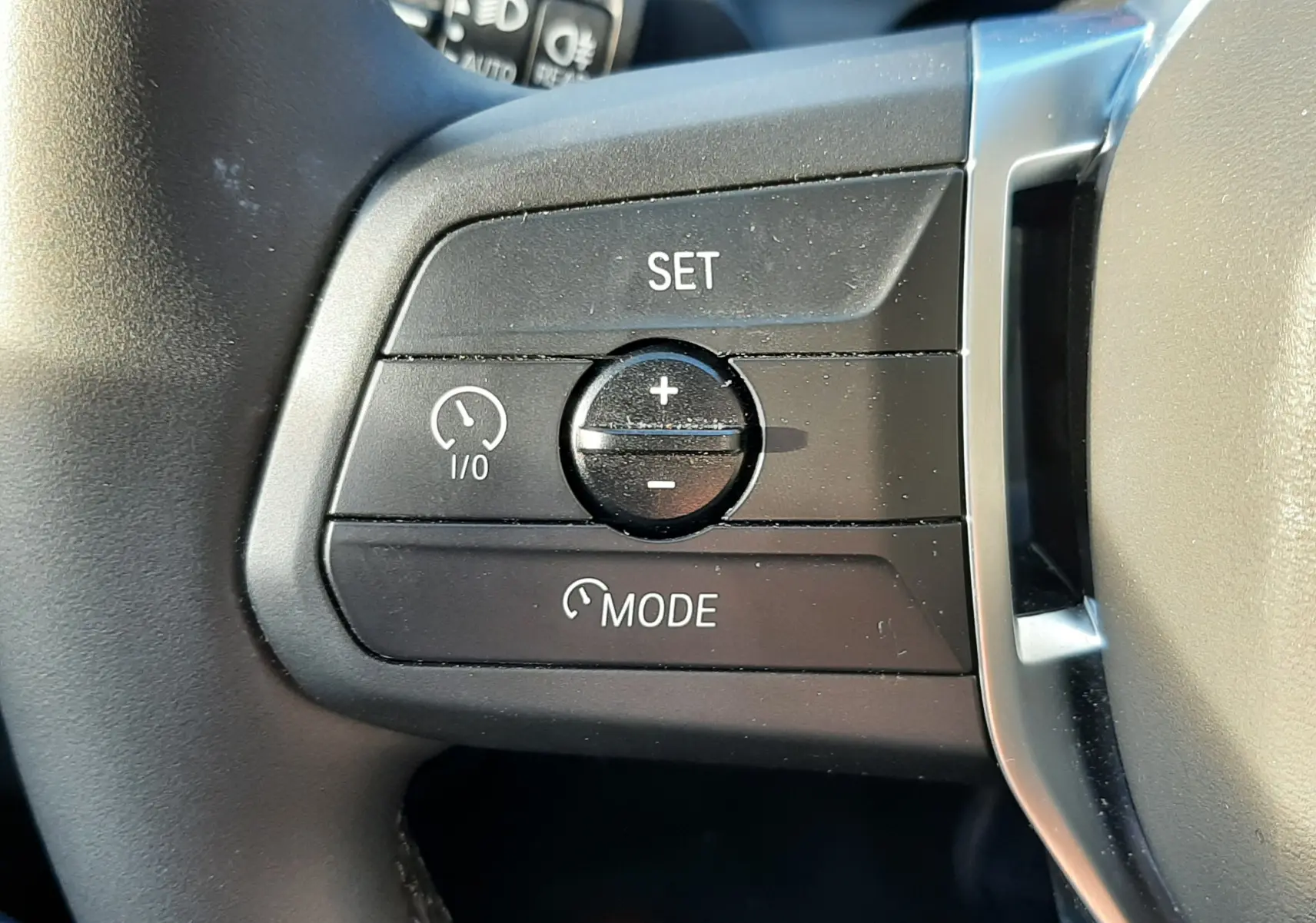 Gros plan sur les commandes de régulateur de vitesse au volant d'une BMW Série 1 120D M Sport Design 2025.