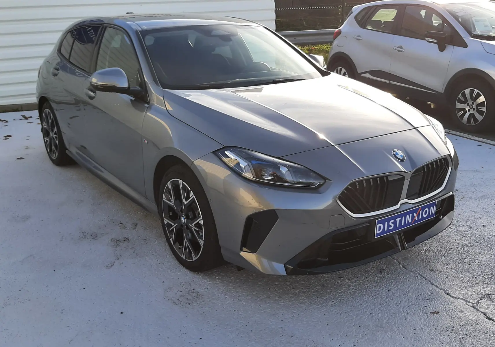 BMW Série 1 gris Skyscraper vue 3/4 avant avec jantes 18'' bicolores et calandre M Sport Design.