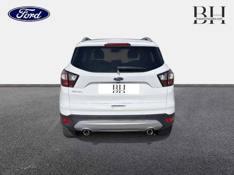 Vue arrière du Ford Kuga blanc Glacier 2017 avec hayon motorisé et double sortie d'échappement visible.