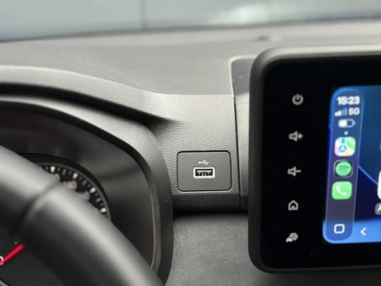 Gros plan sur la prise USB intégrée au tableau de bord du Dacia Sandero Stepway Bleu Iron, avec écran tactile visible.