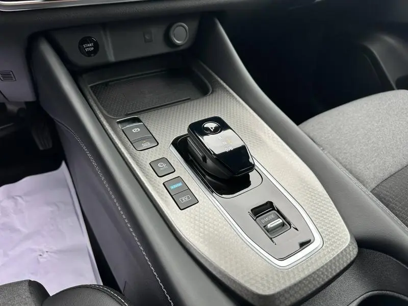 Vue rapprochée de la console centrale du Nissan Qashqai Hybrid e-POWER 2025 avec levier de vitesses et boutons de contrôle.
