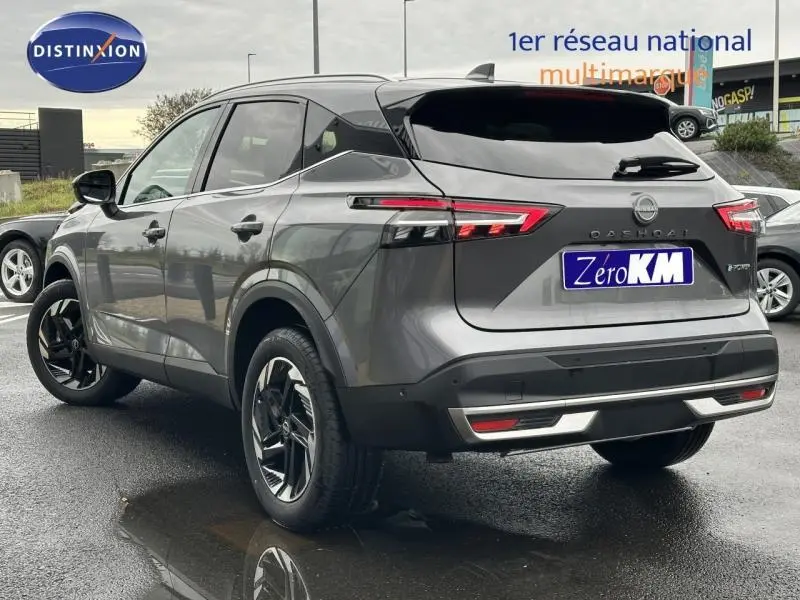 Vue 3/4 arrière droite du Nissan Qashqai Hybrid e-POWER 2025 en gris squale métallisé avec feux arrière LED distinctifs.