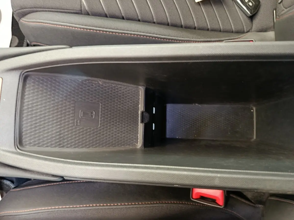 Vue rapprochée de la console centrale noire avec chargeur à induction dans la CUPRA BORN gris foncé 2023.
