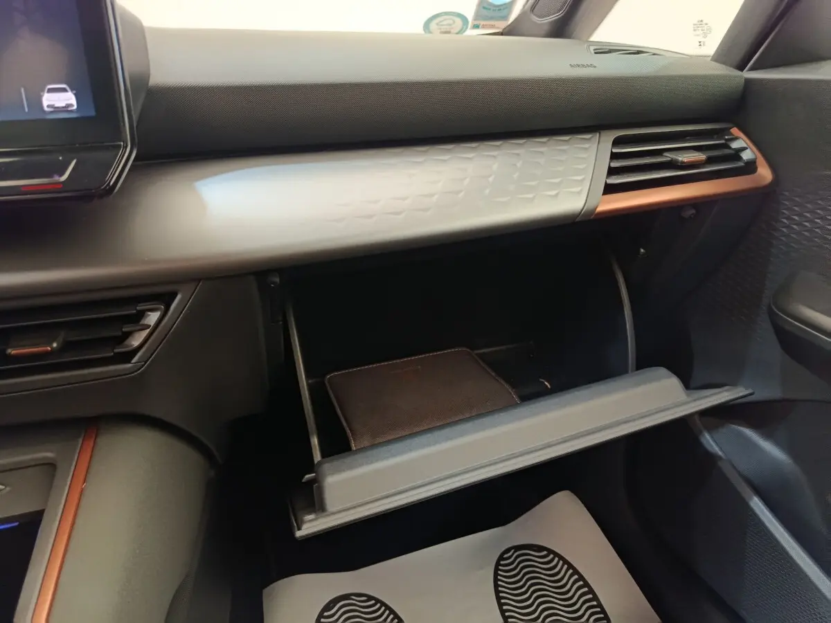 Vue intérieure côté passager du tableau de bord gris foncé avec boîte à gants ouverte du CUPRA BORN 230ch 2023.