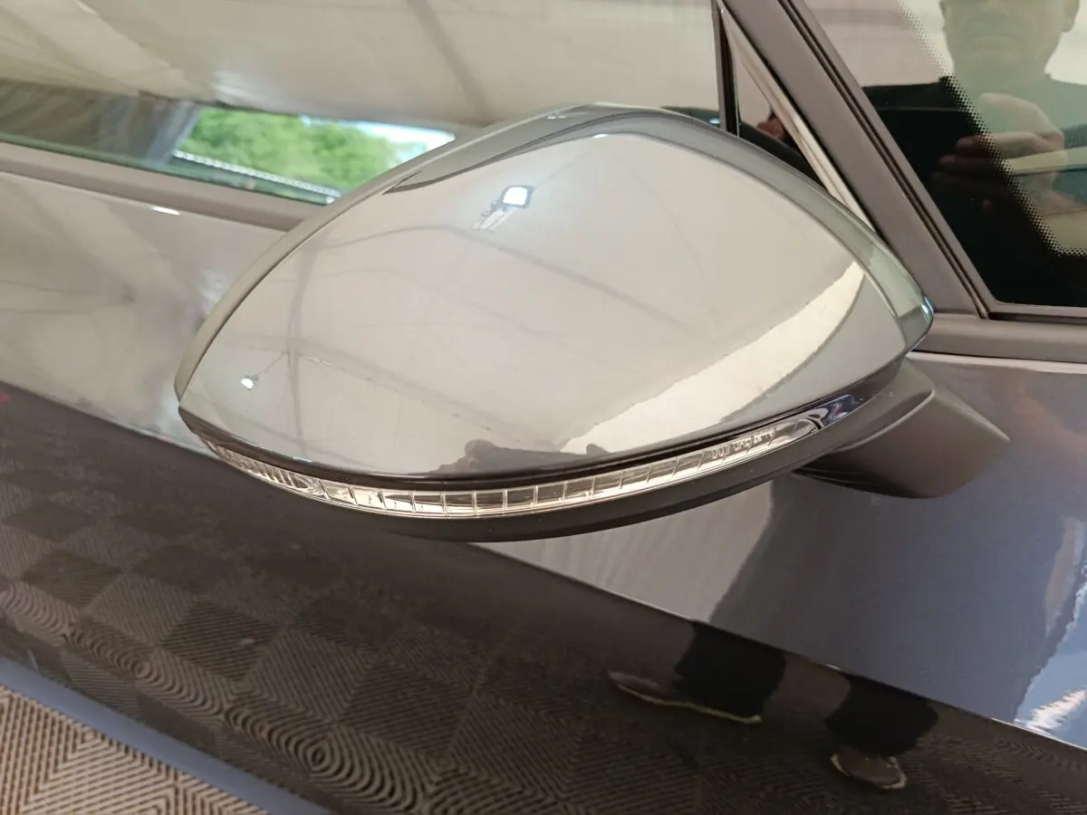 Rétroviseur côté conducteur gris foncé du CUPRA BORN 230ch, avec clignotant intégré visible en gros plan.