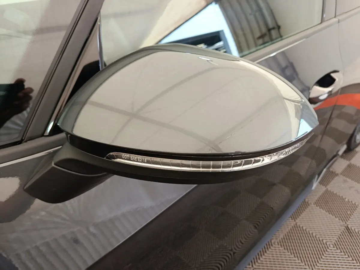 Rétroviseur côté gauche gris foncé de la CUPRA BORN 230ch 2023 avec clignotant intégré, vue rapprochée en intérieur.