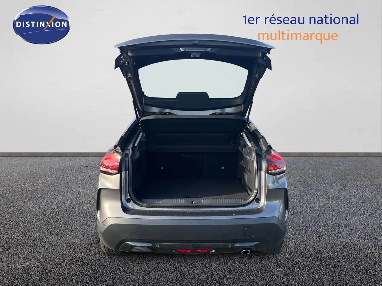 Vue arrière d'une Citroën C4 gris 2023 avec le coffre ouvert, mettant en valeur l'espace de chargement.