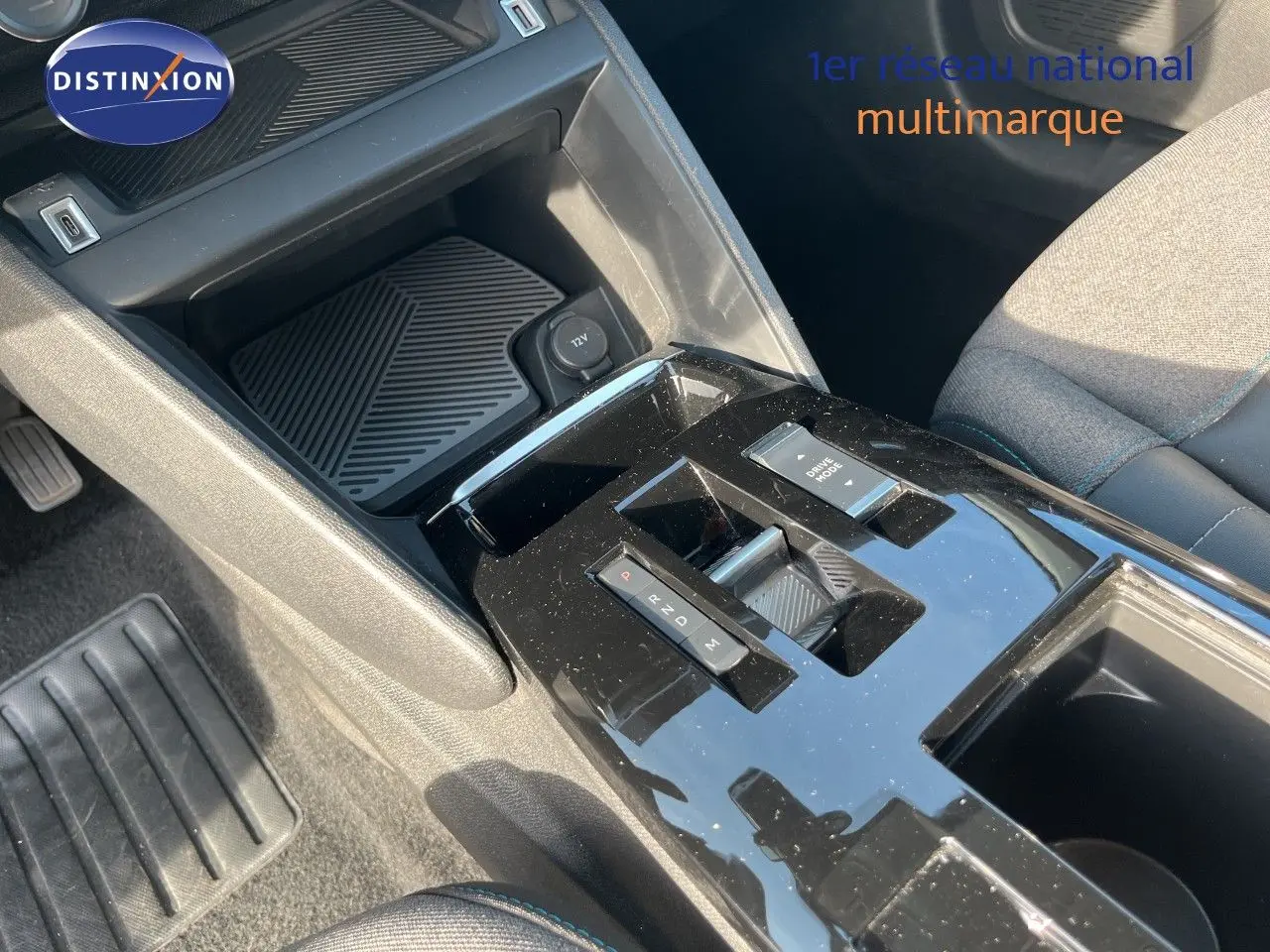 Vue rapprochée de la console centrale noire brillante de la Citroën C4 2023, montrant la commande de boîte automatique et l'espace de rangement.