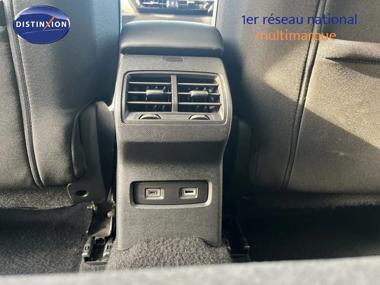 Vue rapprochée de la console arrière noire avec bouches d'aération et deux ports USB dans une Citroën C4 gris 2023.