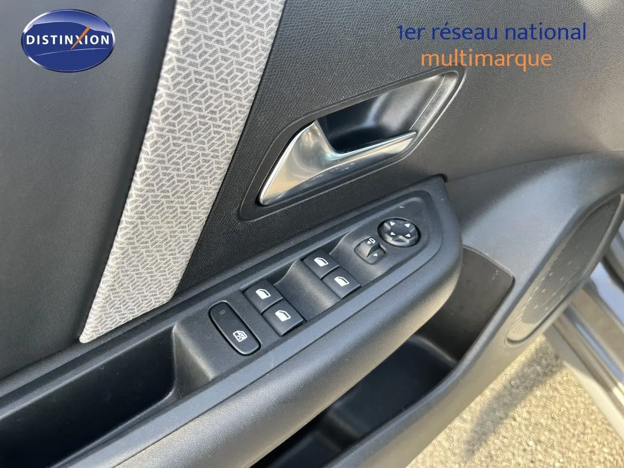 Gros plan sur la porte côté conducteur de la Citroën C4 gris 2023, montrant les commandes des vitres et le bouton de réglage des rétroviseurs.