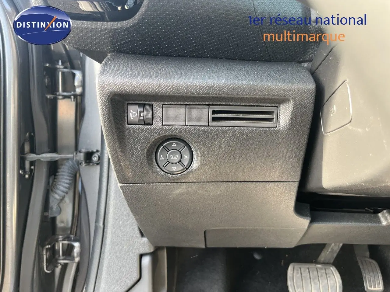 Détail intérieur côté gauche du tableau de bord gris d'une Citroën C4 2023 avec commandes d'éclairage et ventilation.