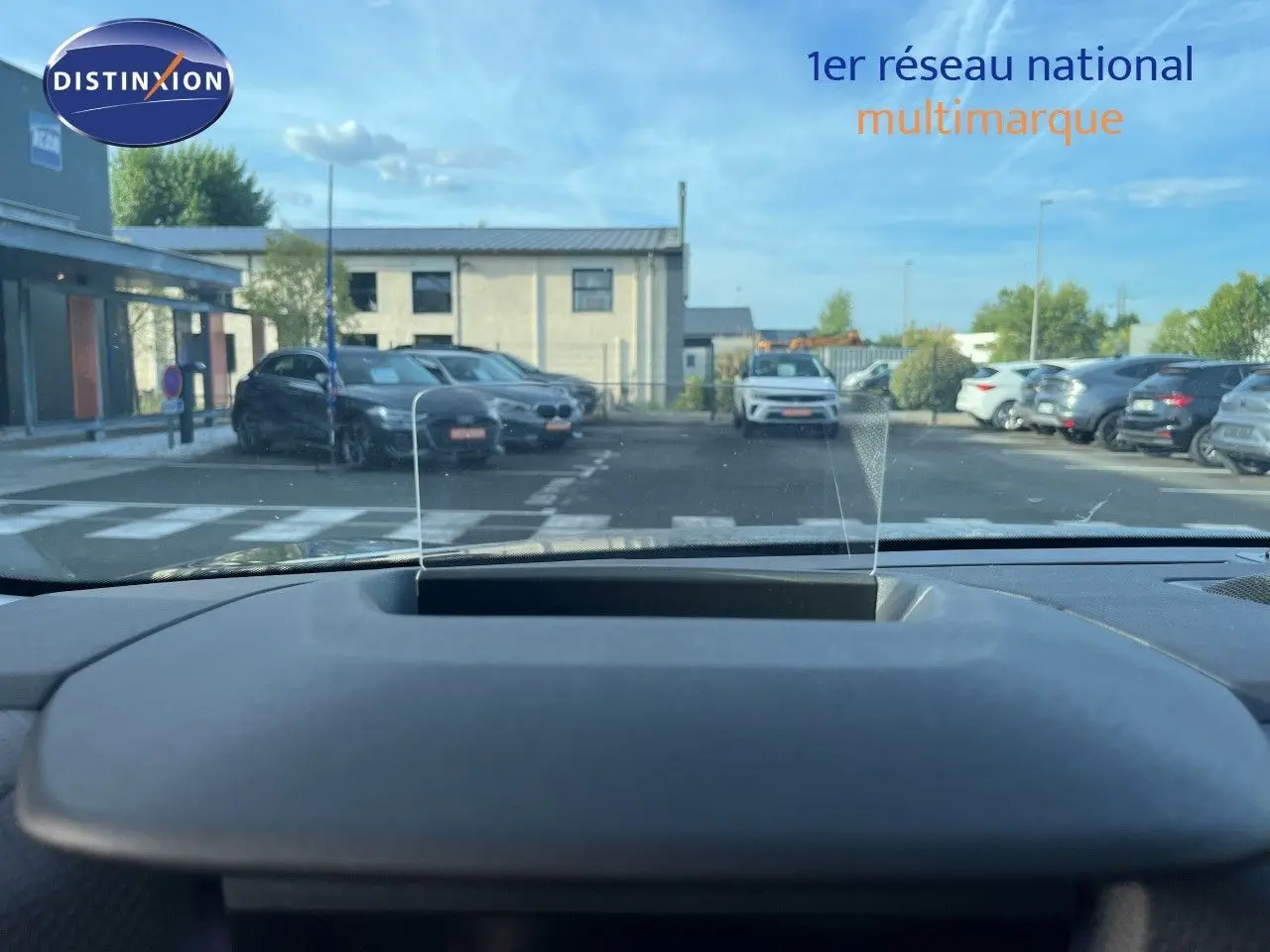 Vue depuis l'habitacle du Citroën C4 gris 2023, montrant le tableau de bord et le pare-brise avec affichage tête haute.