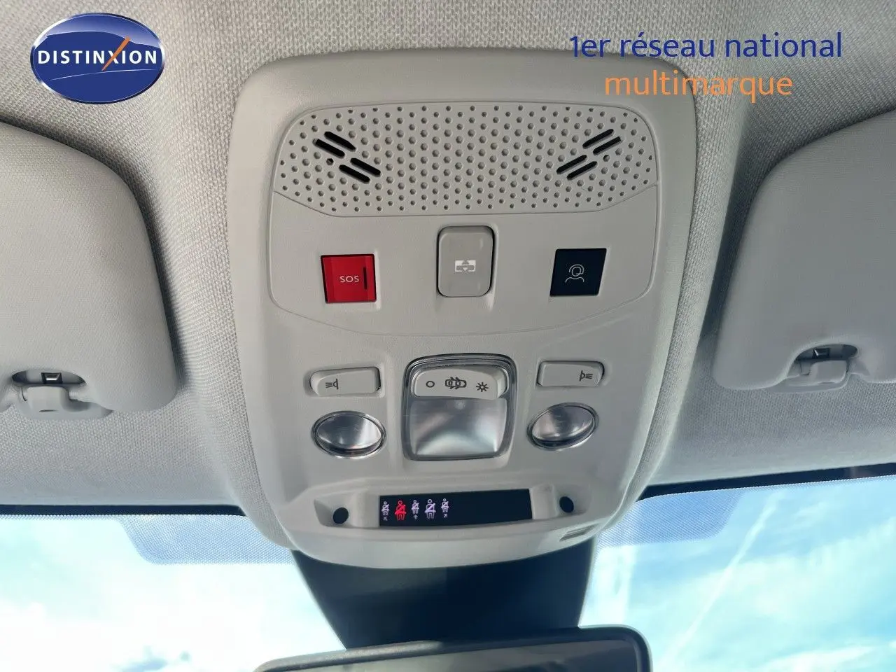Vue intérieure du plafonnier de la Citroën C4 2023 gris, montrant les commandes d'éclairage et le bouton SOS.