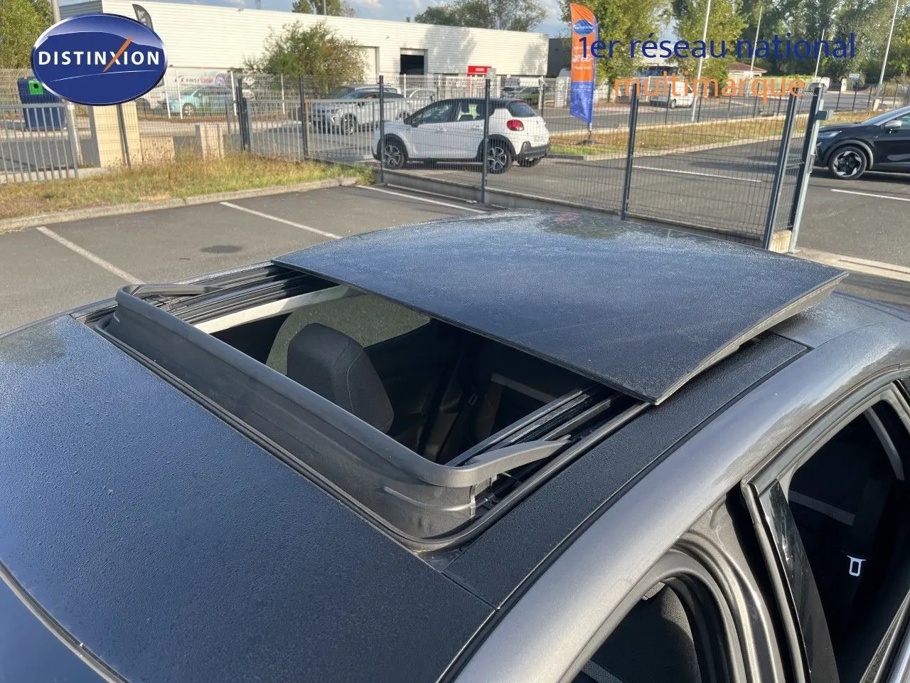 Toit ouvrant panoramique ouvert sur le dessus d'une Citroën C4 gris 3/4 arrière en extérieur.