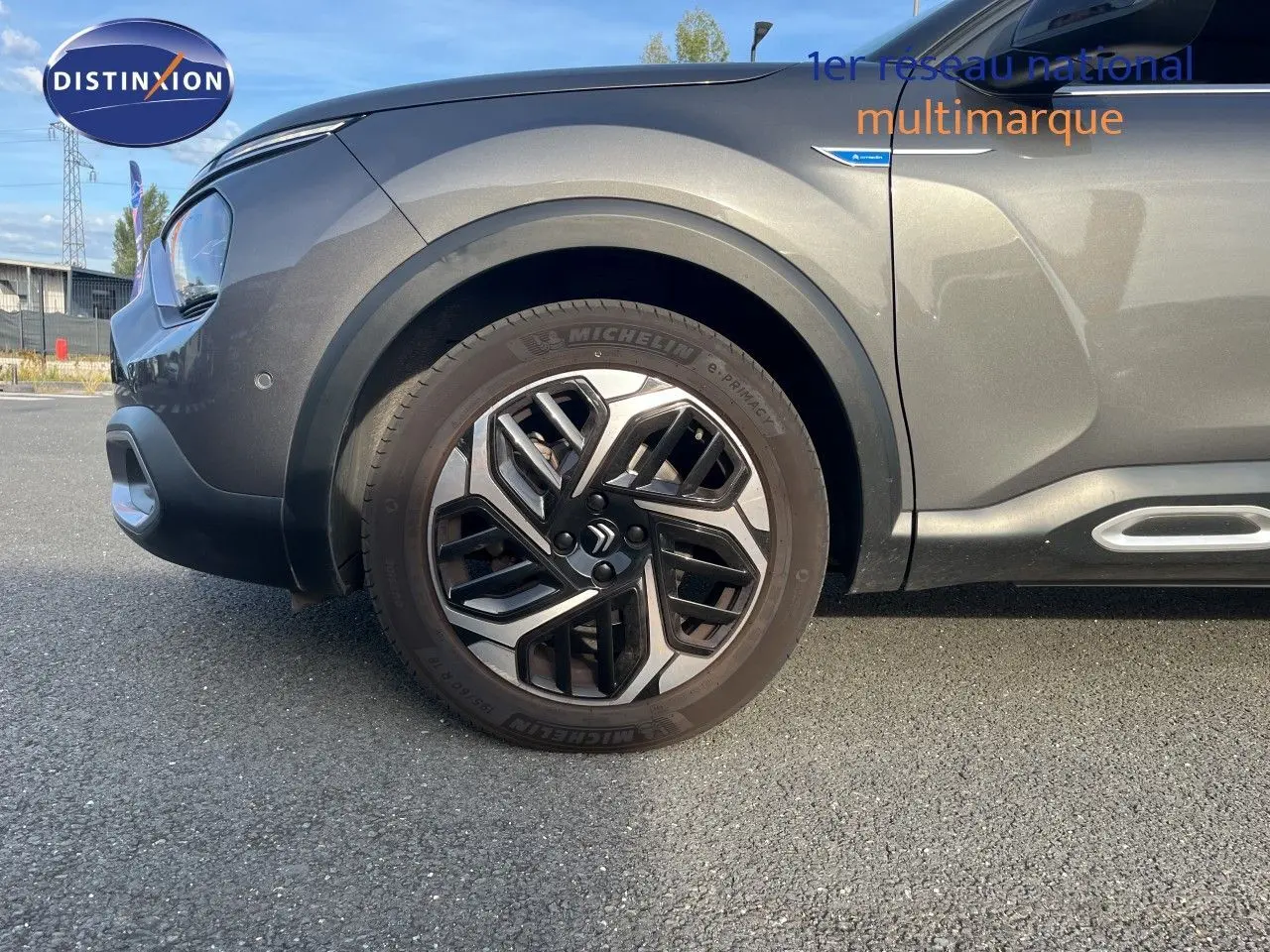 Vue latérale gauche rapprochée sur la roue avant et la carrosserie gris métallisé du Citroën C4 2023.