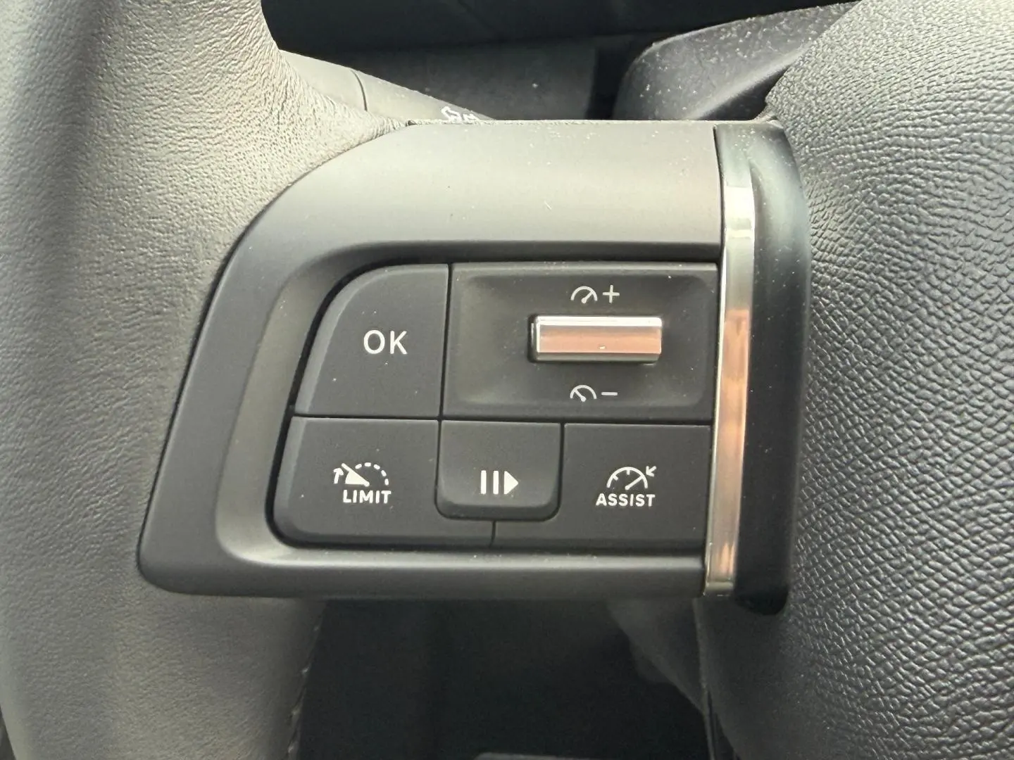 Gros plan sur les commandes noires du volant à gauche de la Citroën C4 électrique blanche 2024.