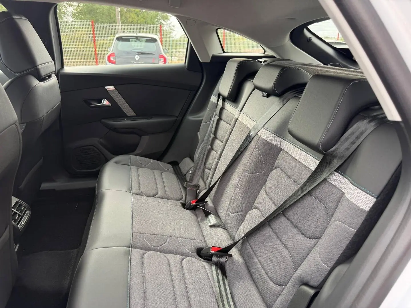 Vue intérieure côté droit de la banquette arrière gris tissu et cuir du Citroën C4 électrique blanc 2024.