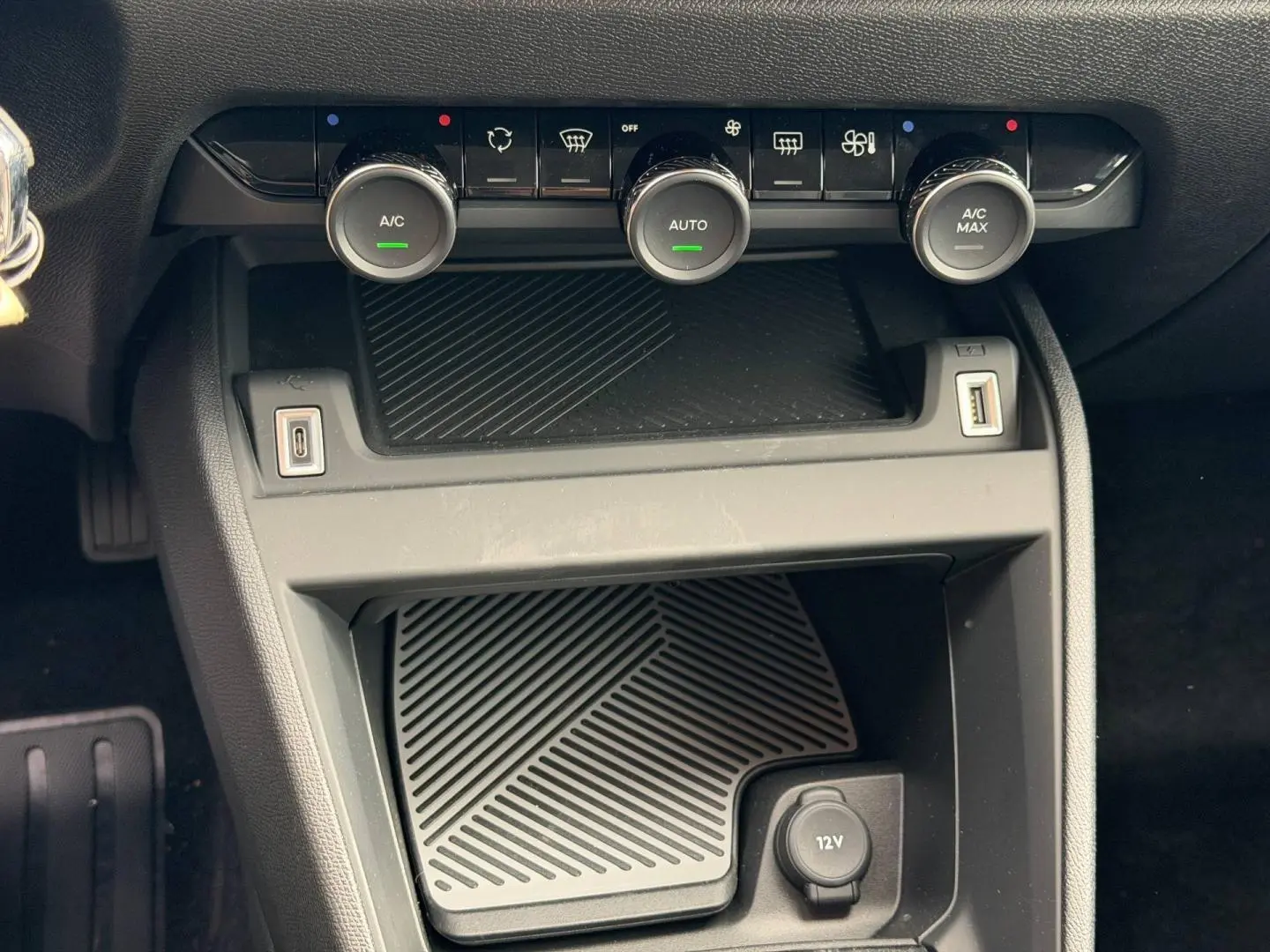 Détail de la console centrale avec commandes climatisation et prises USB du Citroën C4 électrique blanc 2024.