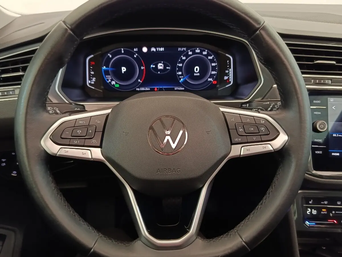 Vue rapprochée du volant cuir multifonctions noir du Volkswagen Tiguan 2.0 TDI 150 DSG7 avec tableau de bord numérique.