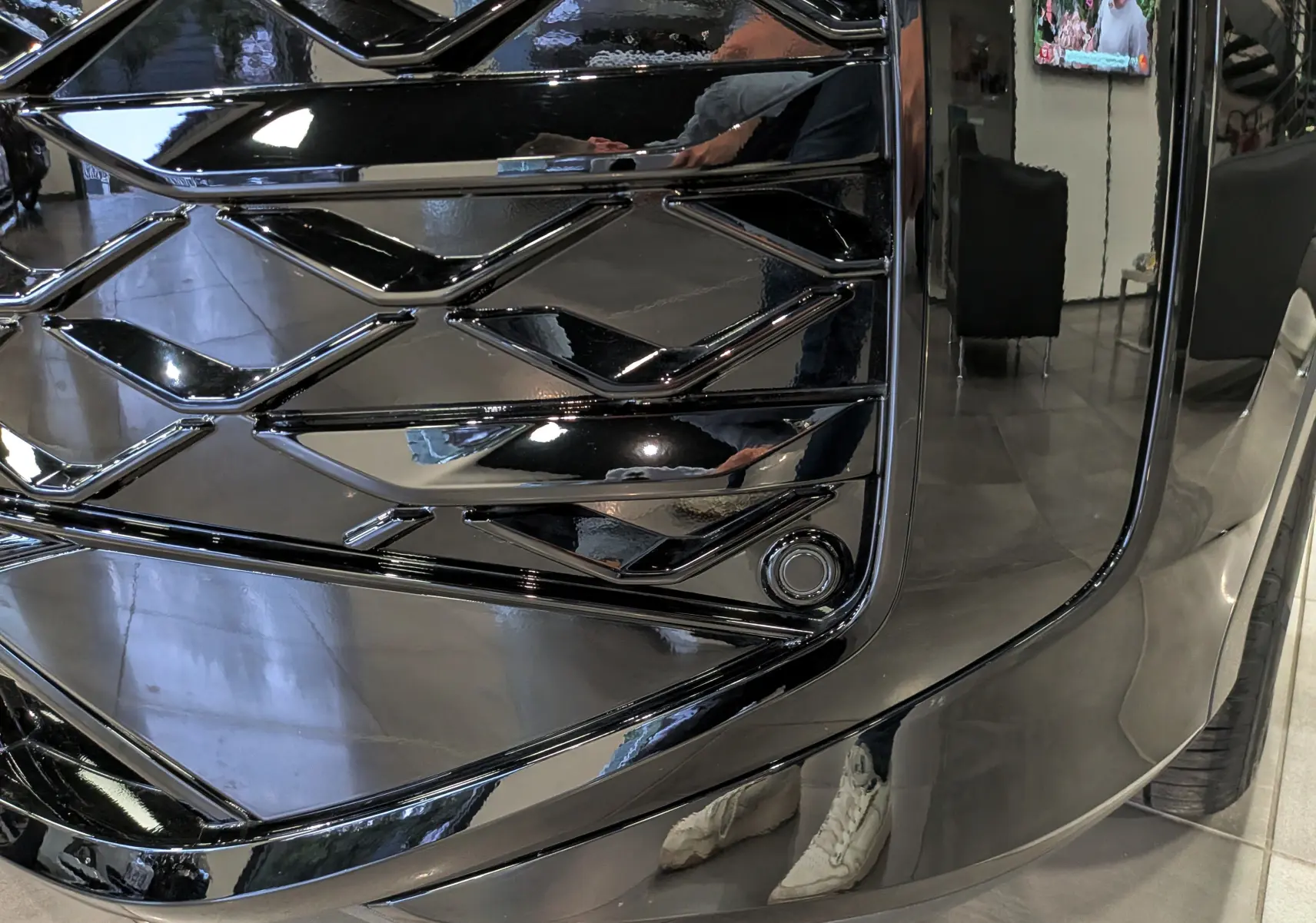 Gros plan sur la calandre noire brillante du Volkswagen T-Roc eTSI 150 CH DSG7 R-Line 2026, soulignant son design géométrique.