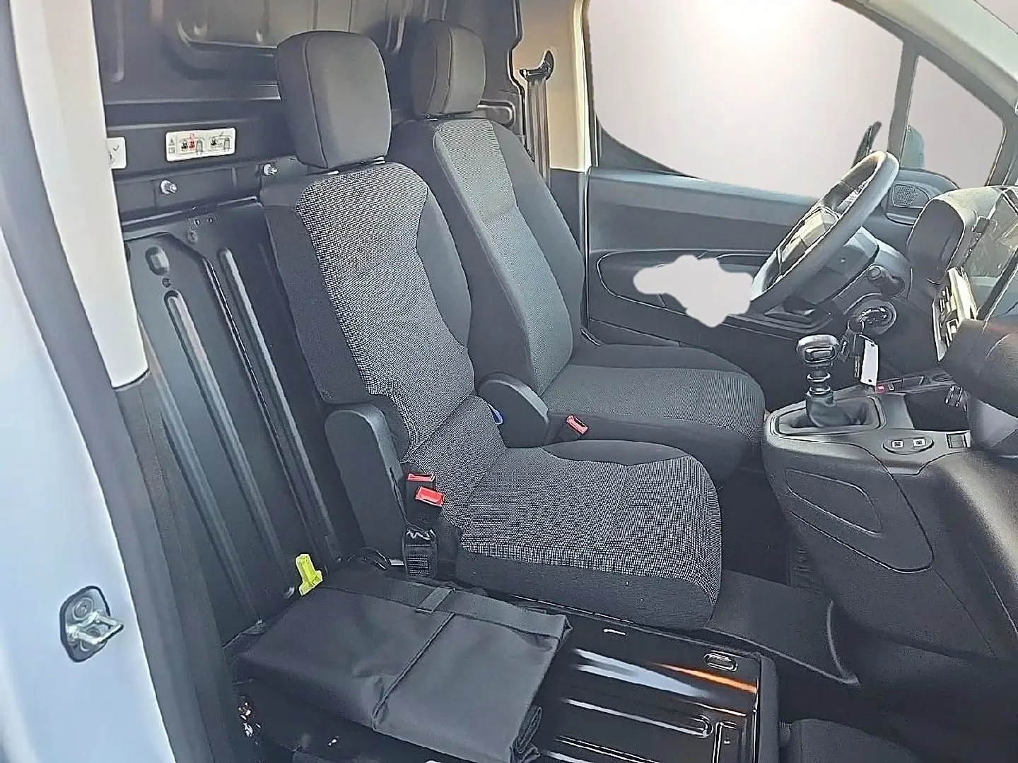 Vue intérieure côté conducteur du Citroën Berlingo Fourgon blanc 2026, montrant les sièges avant et le volant multifonction.