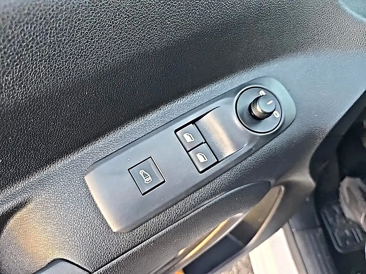Gros plan sur le panneau de commande des vitres et rétroviseurs côté conducteur du Citroën Berlingo Fourgon blanc.