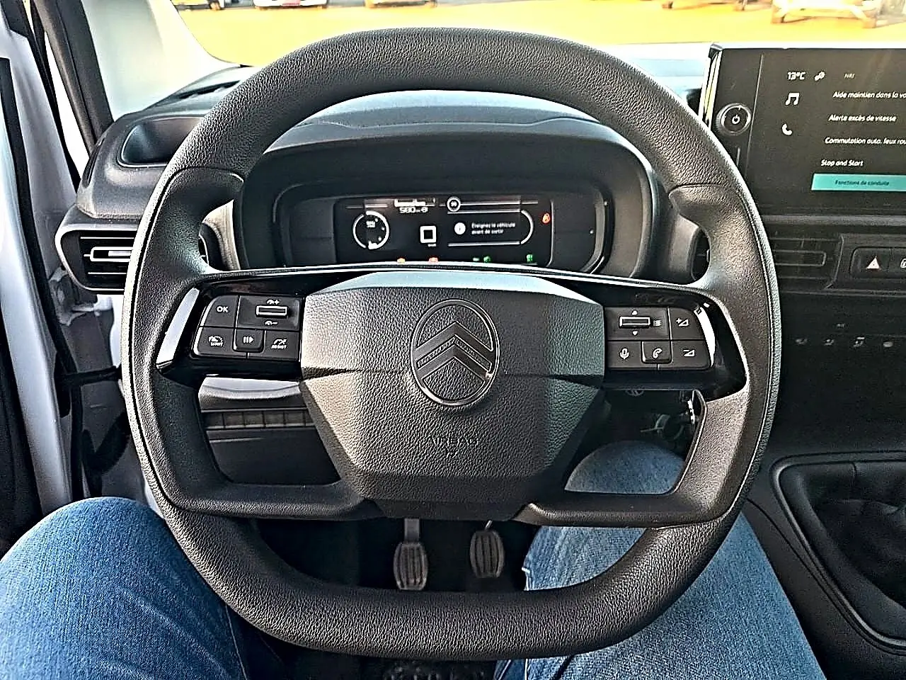 Vue intérieure centrée sur le volant multifonction noir du Citroën Berlingo Fourgon 2026 avec tableau de bord numérique.
