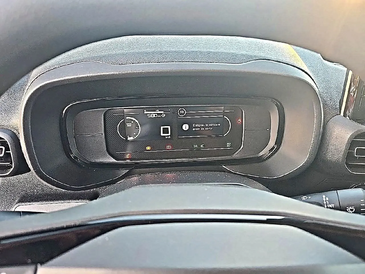 Vue rapprochée du tableau de bord numérique du Citroën Berlingo Fourgon blanc, affichant les informations de conduite.