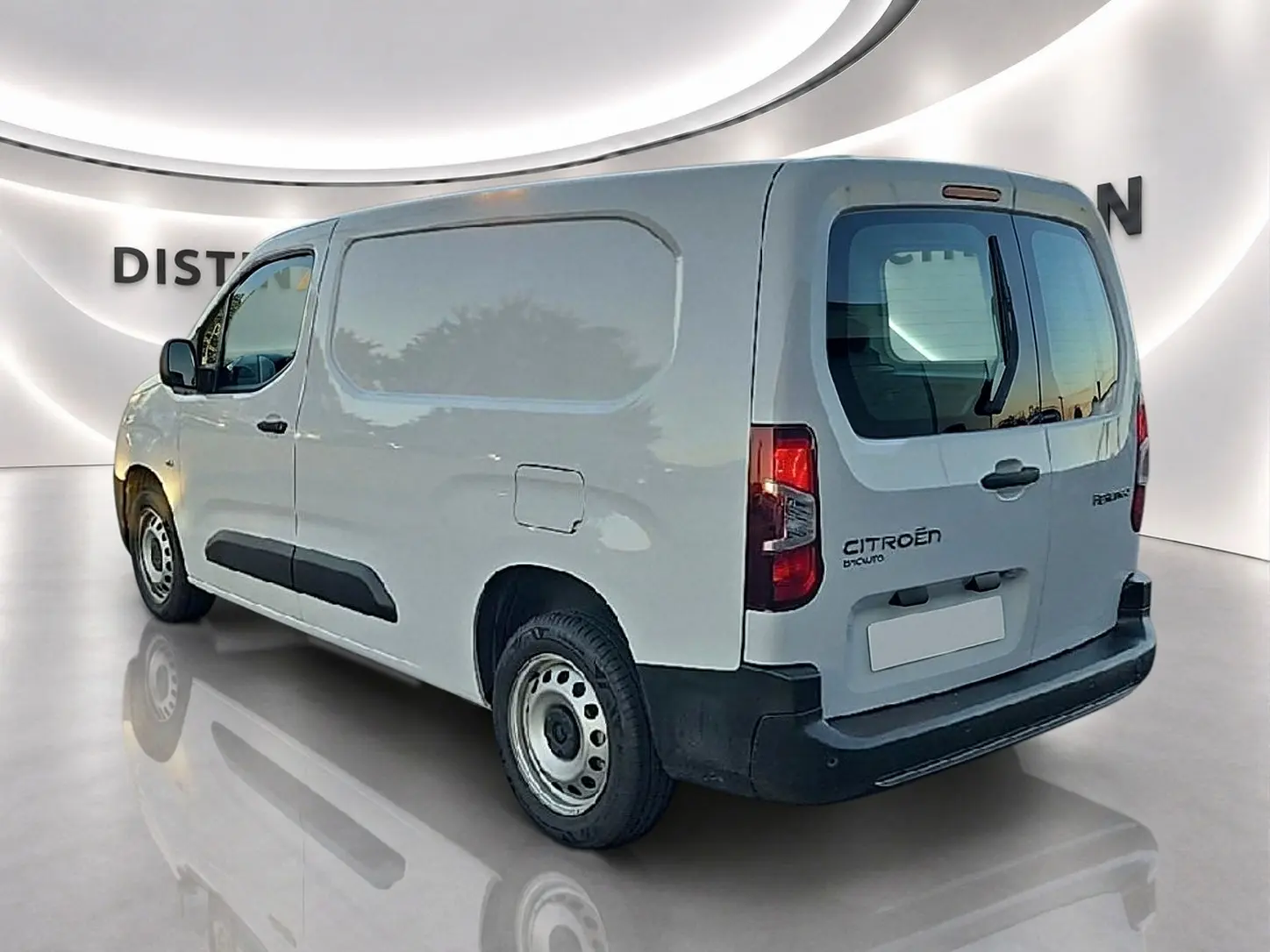 Vue 3/4 arrière droite d'un Citroën Berlingo Fourgon blanc avec porte latérale coulissante et double portes arrière.