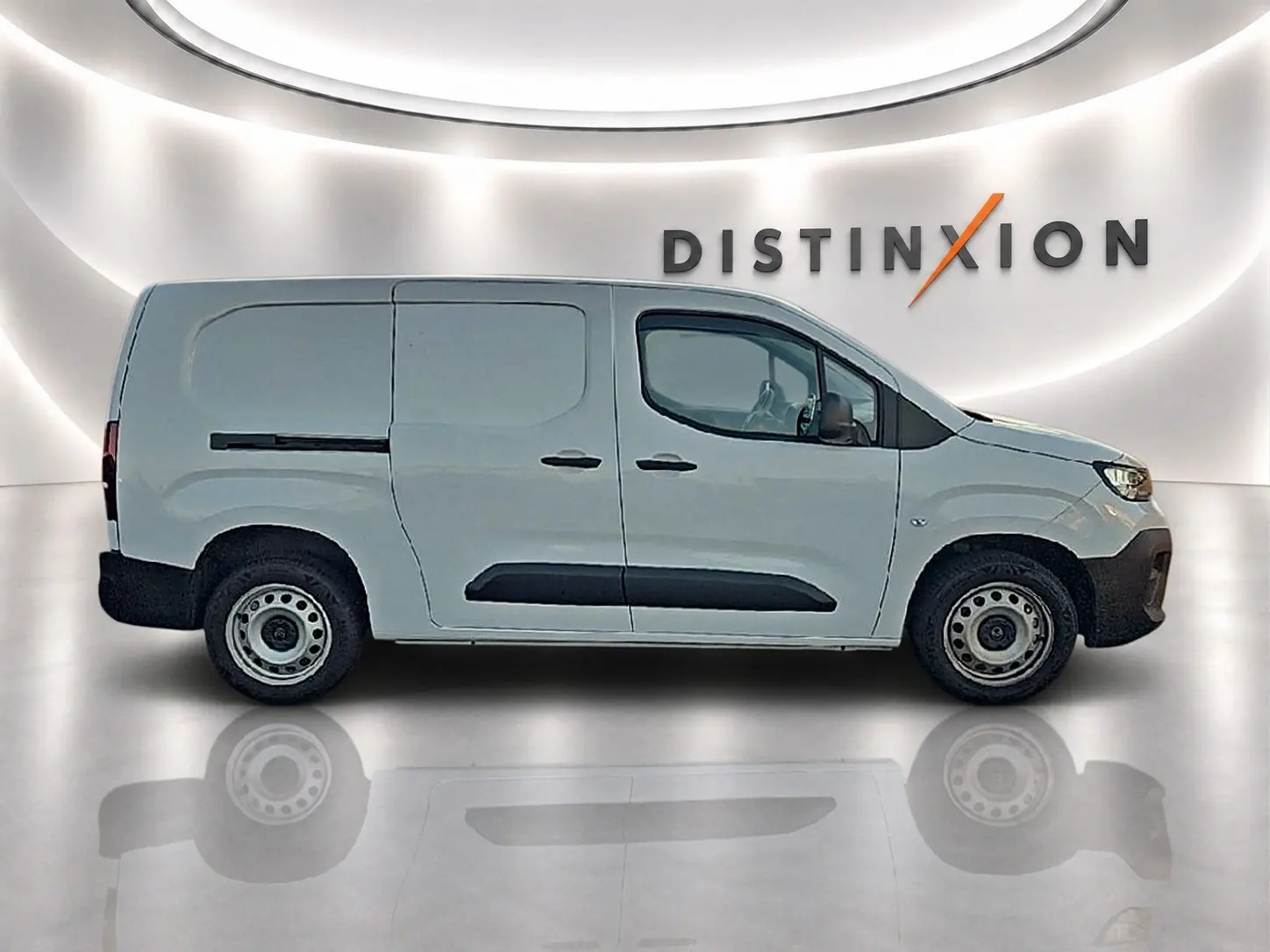 Vue latérale droite du fourgon Citroën Berlingo XL blanc avec porte latérale coulissante, sur fond lumineux "DISTINXION".