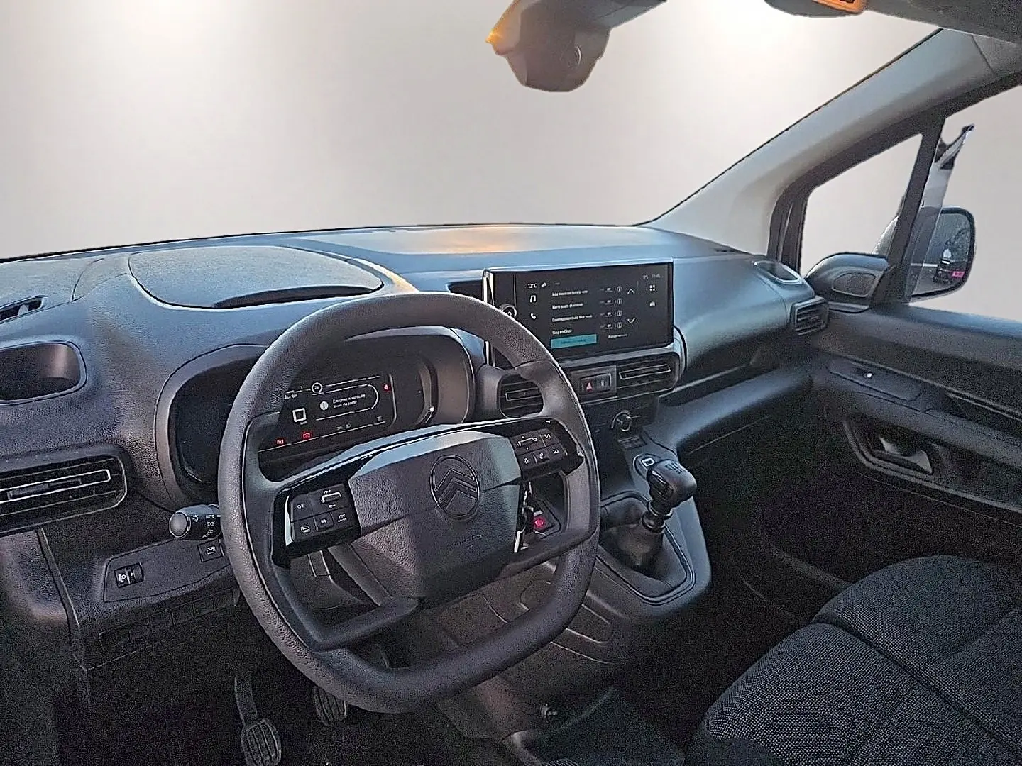 Intérieur du Citroën Berlingo Fourgon blanc, vue côté conducteur, volant multifonction et écran tactile central visibles.