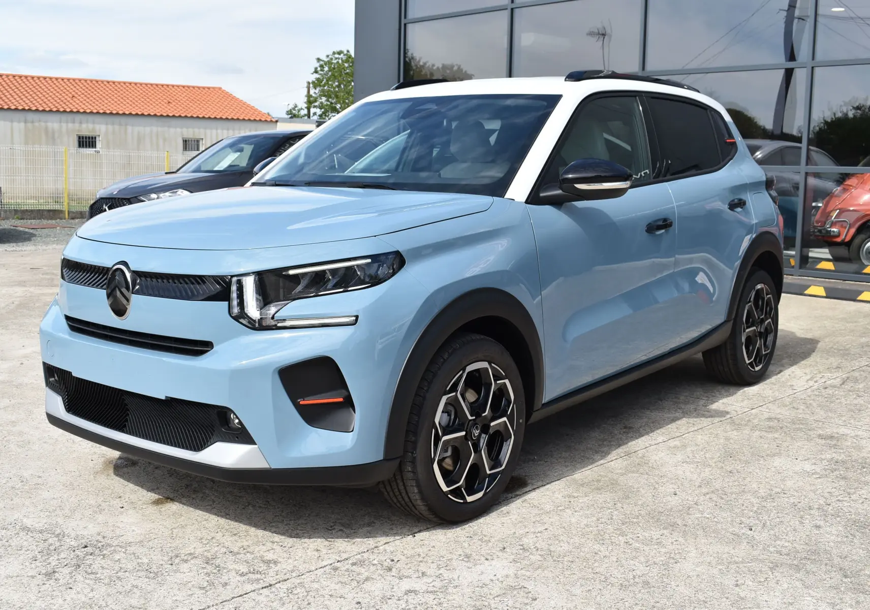 Citroën C3 2025 bleu clair avec toit noir, vue 3/4 avant droit, jantes bi-ton et phares LED distinctifs.