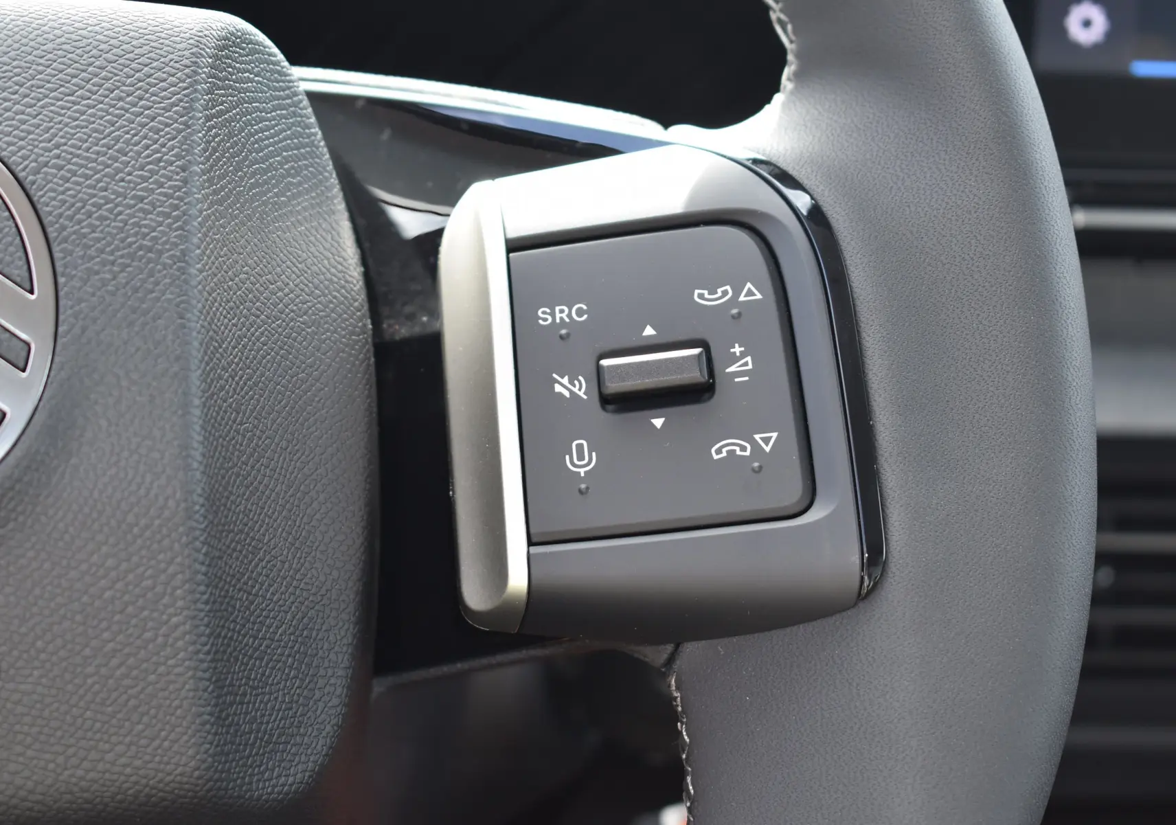 Gros plan sur les commandes multifonctions du volant gris d'une Citroën C3 2025 bleu toit noir, version Turbo 100 CH.