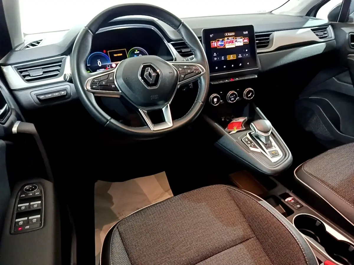 Vue intérieure du tableau de bord et volant cuir du Renault Captur Intens E-Tech hybride rechargeable 2021, avec écran tactile central.