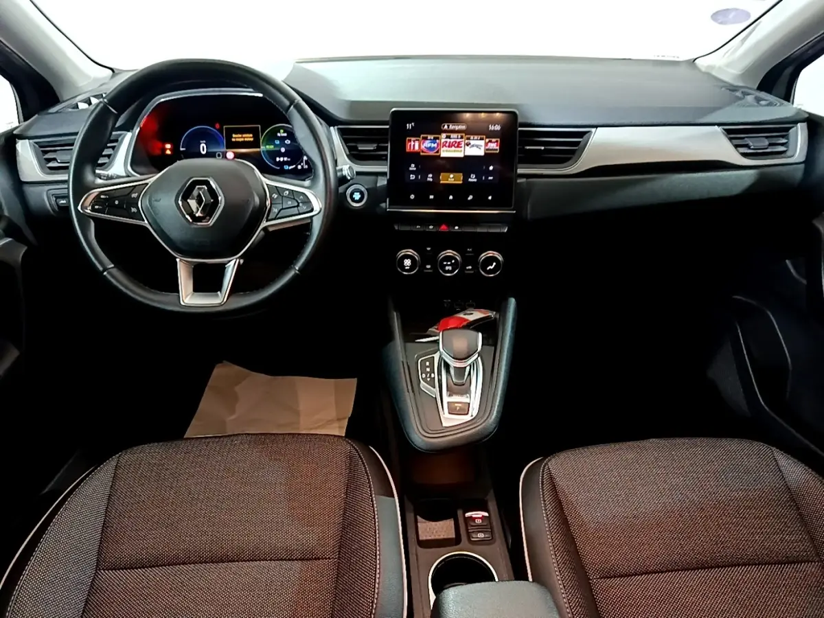 Vue intérieure avant du Renault Captur Intens E-Tech hybride 2021, volant cuir, écran tactile central et levier de boîte auto.