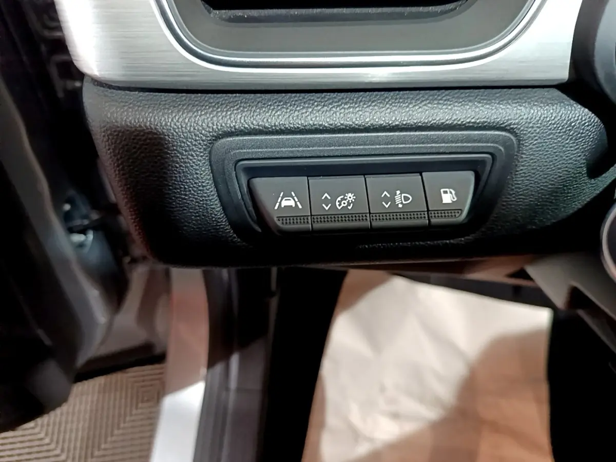 Vue intérieure du tableau de bord côté gauche du Renault Captur gris clair, avec boutons de réglage des aides à la conduite.