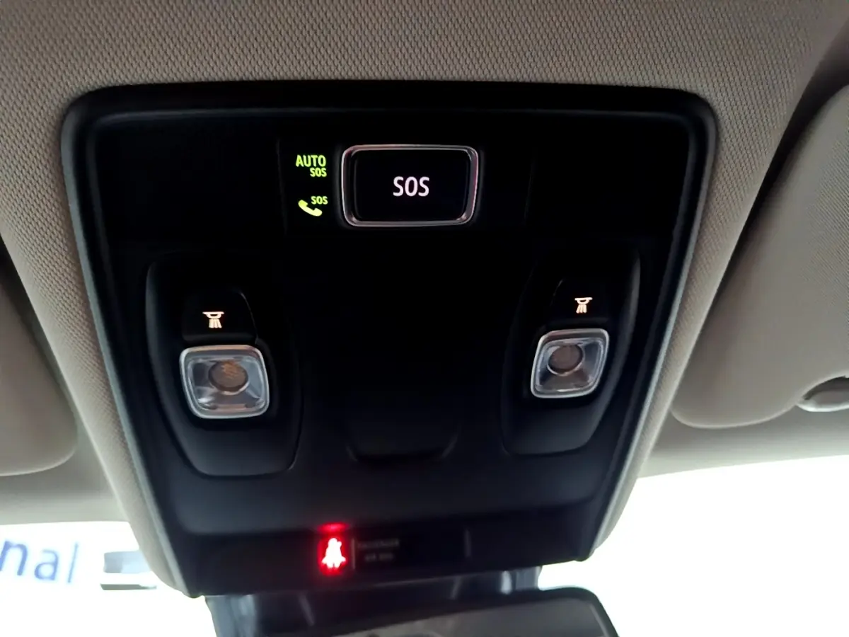 Vue intérieure centrée sur la console de toit noire avec bouton SOS éclairé et plafonnier du Renault Captur gris clair.