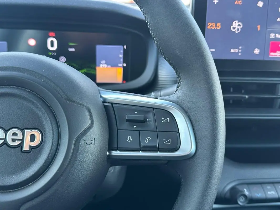 Gros plan sur le volant gris foncé du Jeep Avenger 2025, avec commandes intégrées visibles à droite.