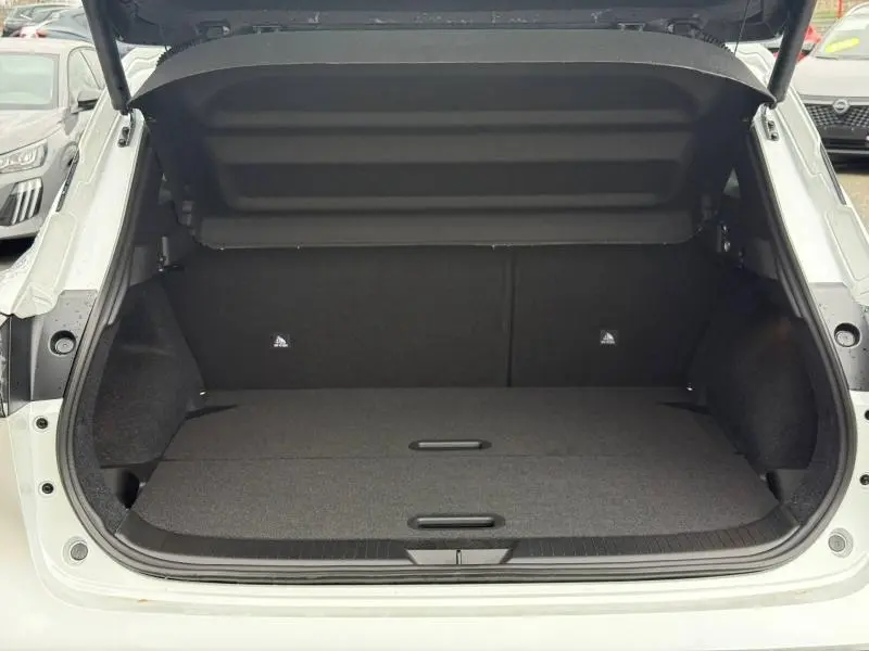 Coffre ouvert vu de l'arrière d'un Nissan Qashqai Hybrid e-POWER 205ch N-Connecta blanc nacré, intérieur noir spacieux.