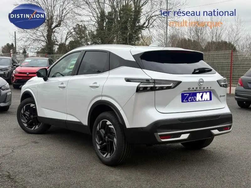 Vue 3/4 arrière droite du Nissan Qashqai Hybrid e-POWER blanc nacré 2025 avec jantes noires et vitres teintées.