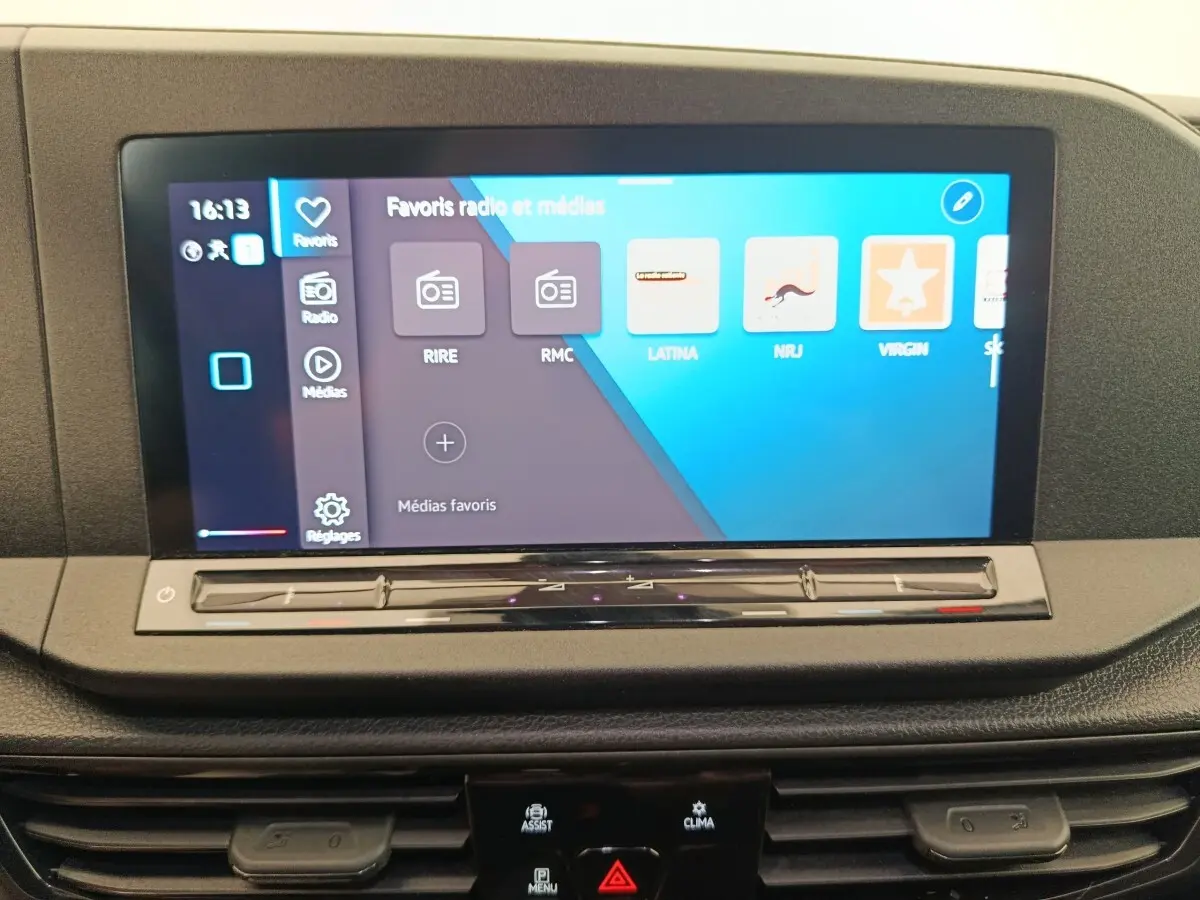 Écran tactile central 10 pouces du tableau de bord du Volkswagen Caddy blanc, affichant les favoris radio et médias.