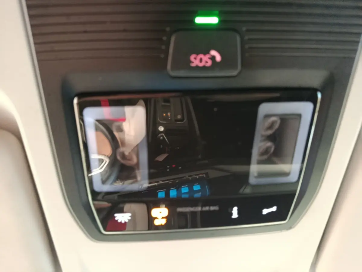 Vue rapprochée du panneau de commande intérieur avec bouton SOS et indicateurs lumineux dans un Volkswagen Caddy blanc 2022.
