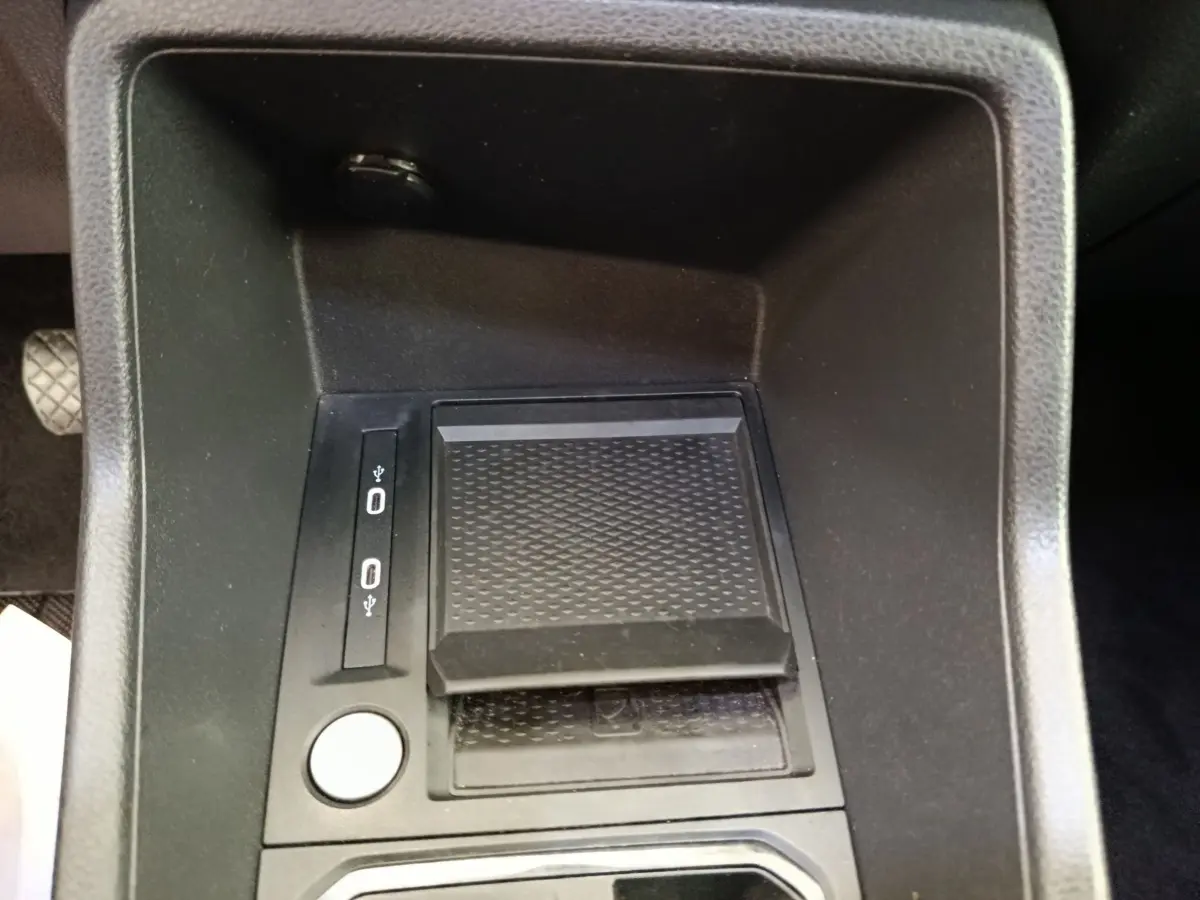 Gros plan sur la console centrale noire du Volkswagen Caddy 2.0 TDI 122ch, avec ports USB et surface antidérapante.