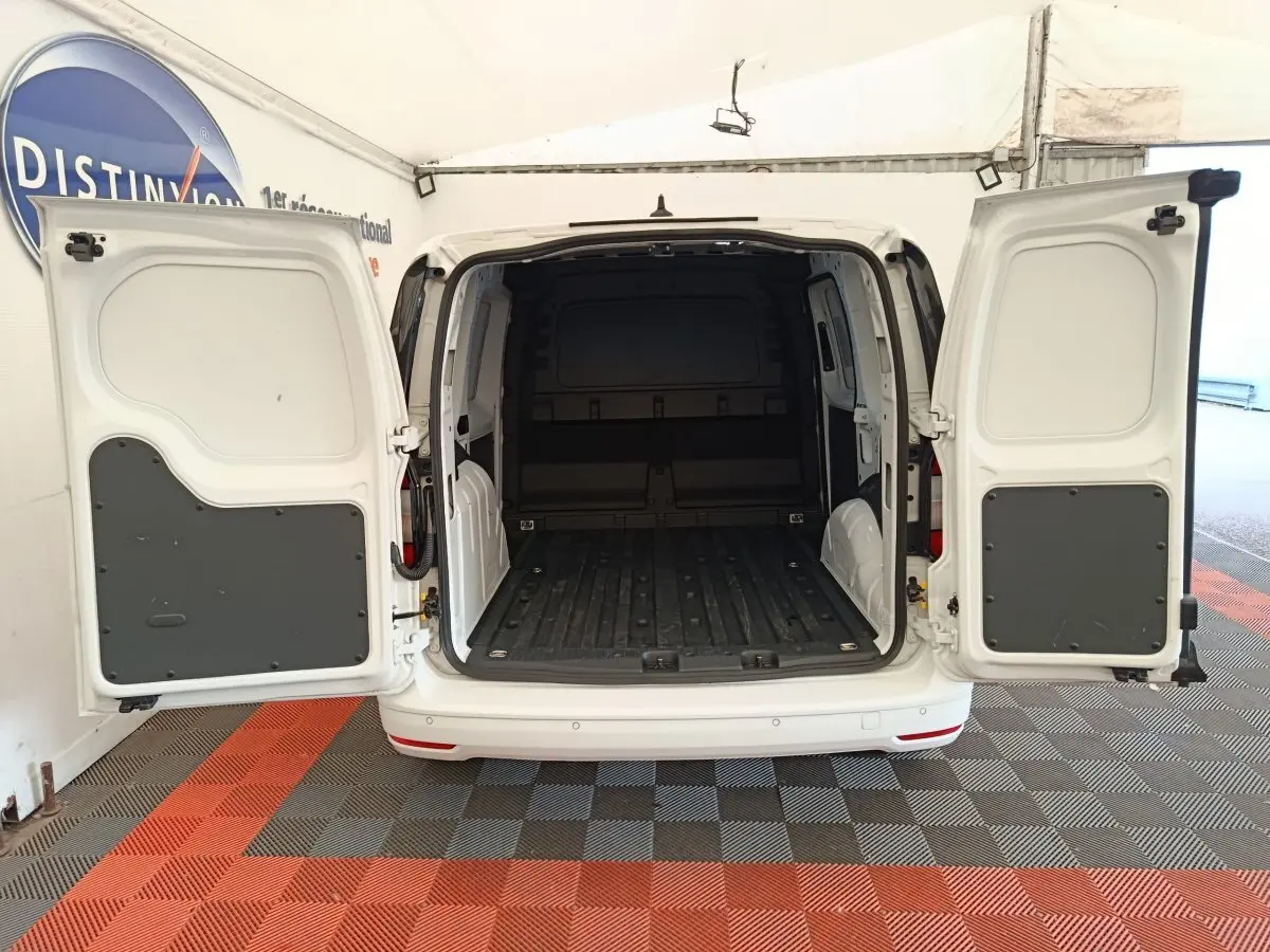 Vue arrière du Volkswagen Caddy blanc 2022 avec portes arrière ouvertes montrant l'espace de chargement vide.